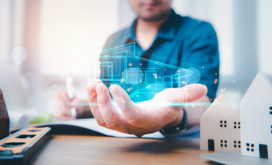 engineers or architects is watching on model building and blueprint on virtual screen in hand.Construction and structure concept.concept of technology design.