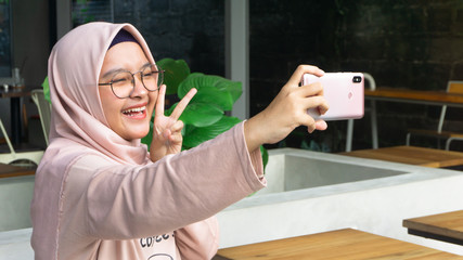 A hijab woman is taking a selfie