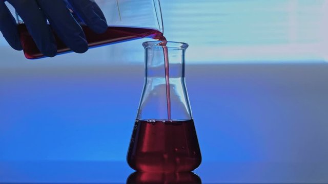 Coronavirus vaccine. Chemical test. Technician hand mixing solution in glass tube.
