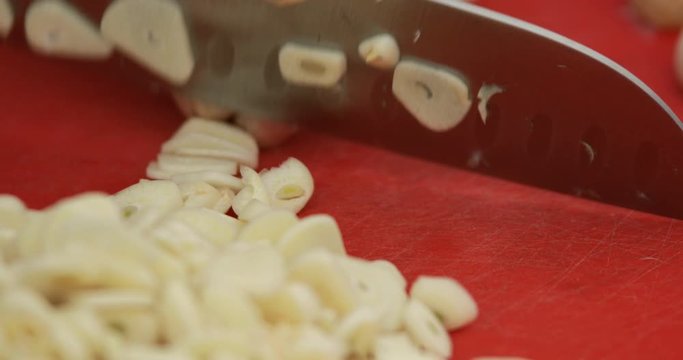 Home made dried garlic powder, raw garlic chopped using sharp kitchen knife, close-up
