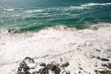 Fototapeta na wymiar white waves of the ocean and stones