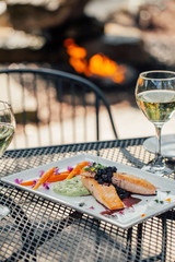 Salmon dish with white wine in an outdoor restaurant setting on a nice day 