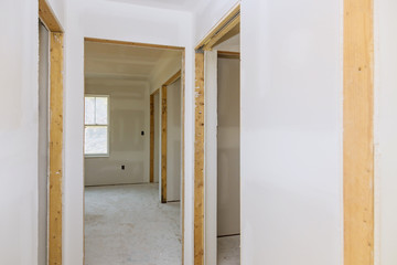 Finishing putty in the room walls plasterboards with room under construction