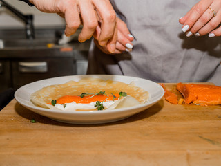 The process of making pancakes. Cook in the kitchen makes the dough.