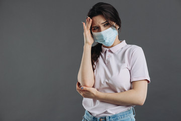 Portrait of a sick headache young woman wearing medical mask. Pandemic 2019 Coronavirus 2019-nCoV Concept.