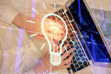 Double exposure of woman hands working on computer and light bulb hologram drawing. Top View. Idea concept.