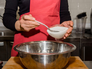 The process of making pancakes. Cook in the kitchen makes the dough.