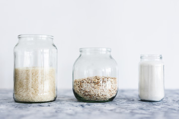 non-perishable food ingredients for vegan pantry, glass jars with oats flour and rice