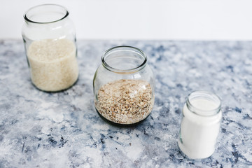 non-perishable food ingredients for vegan pantry, glass jars with oats flour and rice