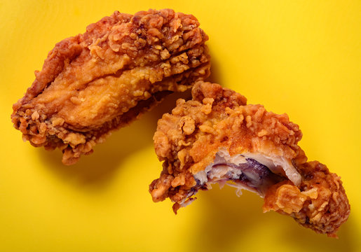 Top View Fresh Deep Fried Chicken Drumstick And Wing With A Bite On Yellow Background