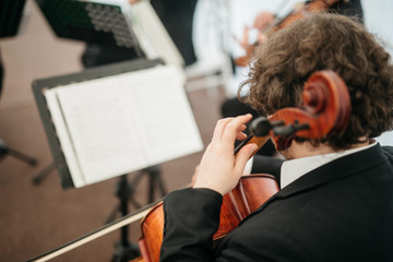  The musician in the band plays the cello in front of the notes