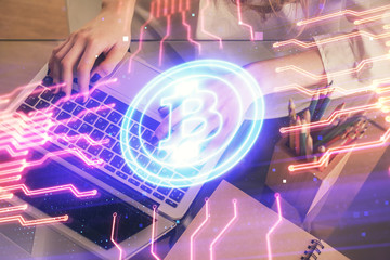 Double exposure of woman hands typing on computer and crypto market theme hologram drawing....