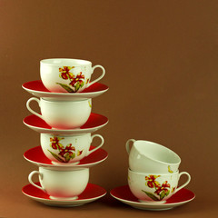 many cups and saucers stand on top of each other, a high tower of kitchen utensils, tea and coffee