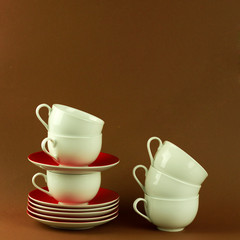 many cups and saucers stand on top of each other, a high tower of kitchen utensils, tea and coffee