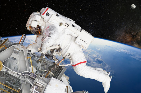 Astronaut on space mission with moon and earth on the background. Elements of this image furnished by NASA.
