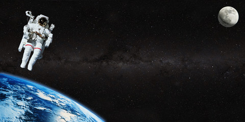 Astronaut on space mission with moon and earth on the background. Elements of this image furnished...