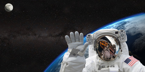 Astronaut on space mission with moon and earth on the background. Elements of this image furnished...