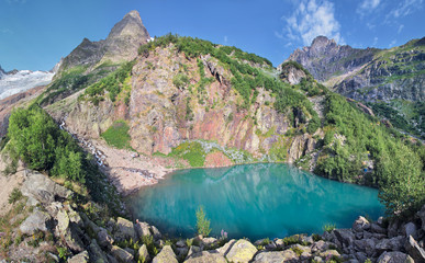 A picturesque lake in the Caucasus Mountains, Dombay. Water, rocks and summer greens.