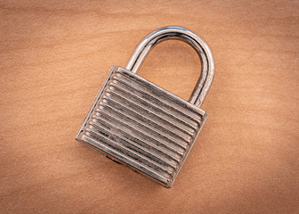 A closed padlock on a wooden surface