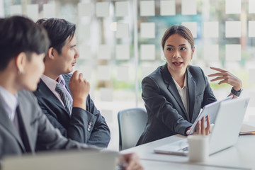 Group of young asian modern business people talking and smiling during the meeting in office.