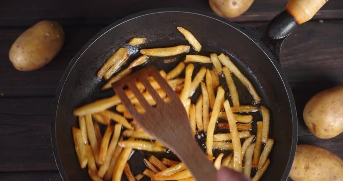French fries fry in a pan in boiling oil.
