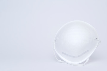 White single paper medical mask on light grey backdrop.  Health protection, medicine  concept. Front view, Copy space