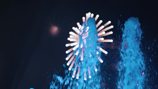 Dolly zoom watering fountain and fireworks at festival Tomorrowland in slowmotion.