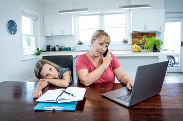 COVID-19 school lockdowns and remote working. Stressed woman working from home with bored daughter