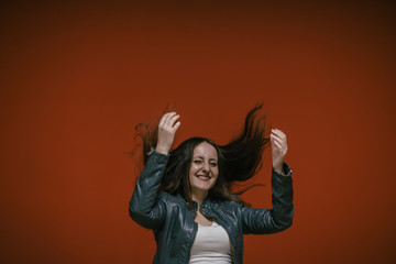 happy girl jumping on the background of the red wall in the underground parking of the shopping center