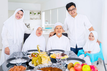 Muslim family looking at camera together at home