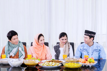Muslim people talking to each other in dining room