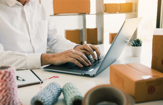 Entrepreneurs are working on taking orders of customers products by typing information tpying keyboard laptop computer in office room.
