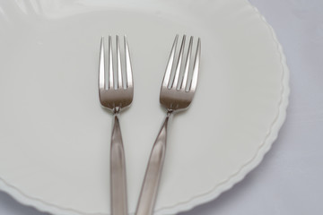 two forks on a white plate