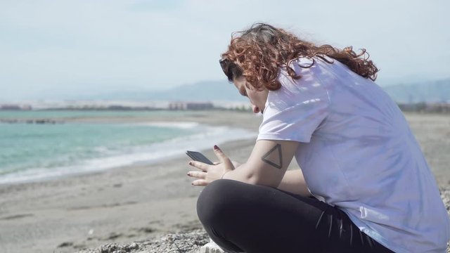 Young Woman With Phone On Beach