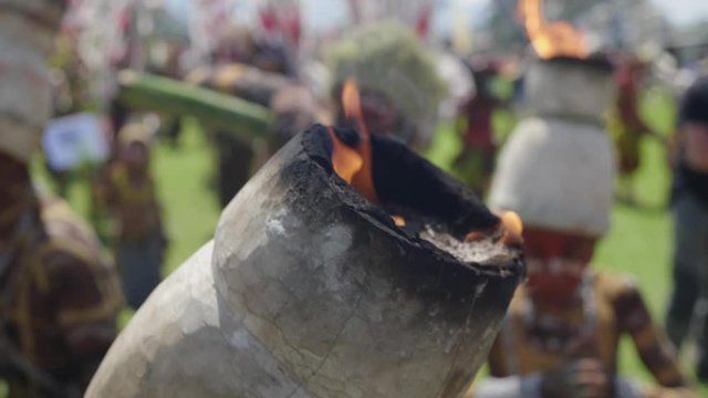 Close up focus shot, flaming tribal headdress in Goroka festival, tribal dance in the background.