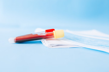 test tubes with blood next to white masks on a blue background