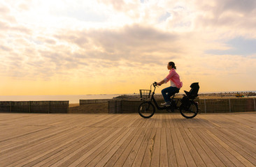 Fototapeta na wymiar 自転車に乗る女性　夕方海沿い