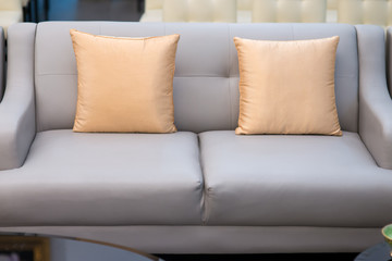 light orange pillow on grey sofa