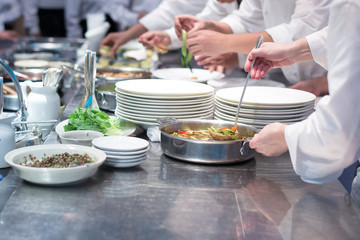 Busy team chefs in commercial  hotel kitchen