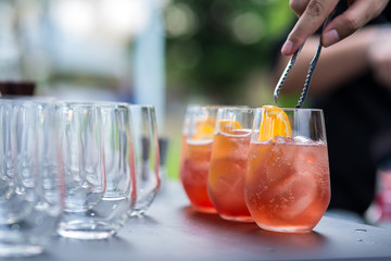 Bartender pouring cocktail in glasses