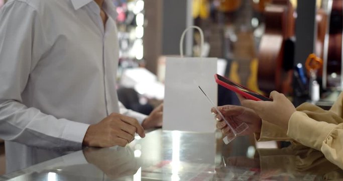 Young woman paying by scanning QR Code with smartphone