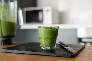 tasty and healthy food for vegetarians. Green smoothie of vegetables and fresh herbs is poured into a glass. Natural antioxidant.