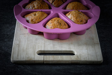 Homemade cupcakes in a baking mould on a wooden board