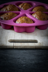 Homemade cupcakes in a baking mould on a wooden board
