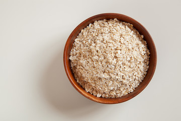 Dry oatmeal in a round wooden plate.