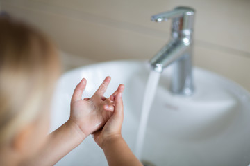 Obraz na płótnie Canvas Hygiene concept. Kid Washing hands with soap under the faucet with water. Hygiene to stop spreading coronavirus.