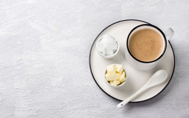 Bulletproof coffee in white ceramic cup blended with butter and coconut oil. paleo, ketogenic drink breakfast