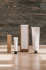Cosmetic white tube and paper box on wooden table - 332572761