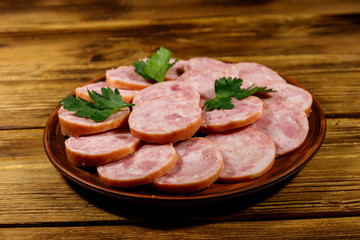 Ham sausage on a plate on wooden table