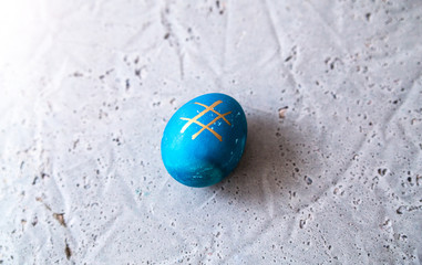 Blue egg with hashtag pattern on concrete surface